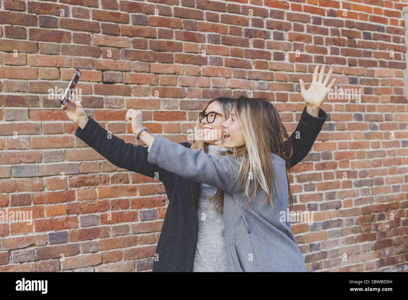Zwei Hipster-Freundinnen machen ein Selbstfoto fuer soziale Netzwerke im urbanen Stadthintergrund - Freundschaftskonzept Foto Stock
