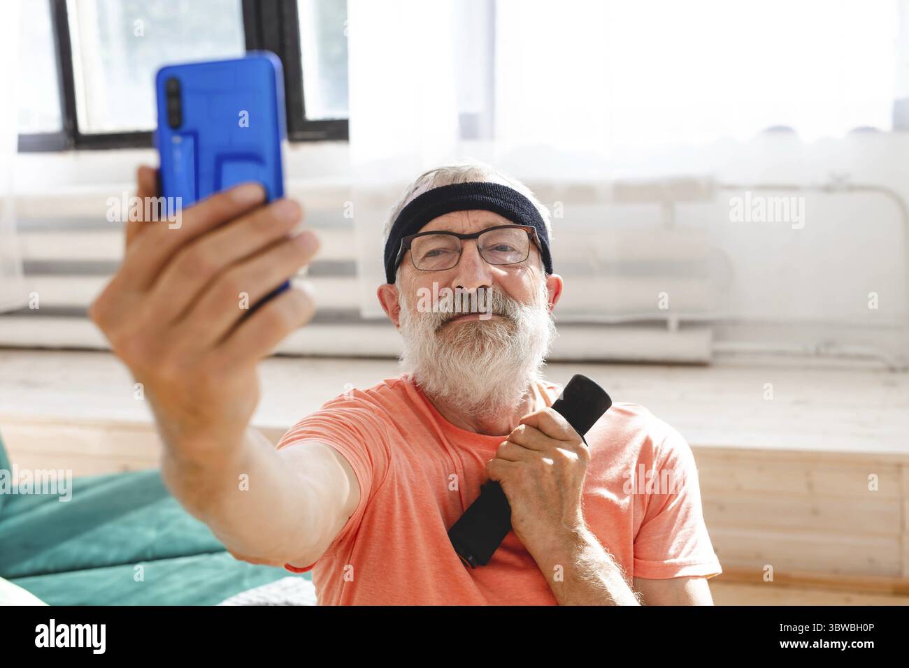 Aeltere Maenner nehmen Selfie fuer soziales Netzwerk waehrend der Ausuebung mit Dumbbells. Alter Mensch Rentner gesunde Ausbildung Gesundheitssport zu Foto Stock