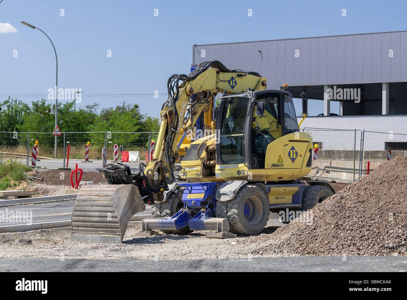 Wickrange, Lussemburgo - Vista su un escavatore gommato giallo Mecalac 15MWR per lavori in terra in cantiere. Foto Stock