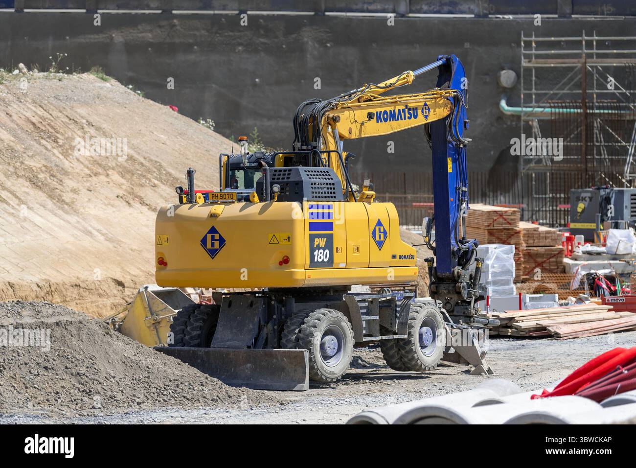 Wickrange, Lussemburgo - Vista su un escavatore gommato giallo Komatsu PW180-11 per lavori in terra in cantiere. Foto Stock