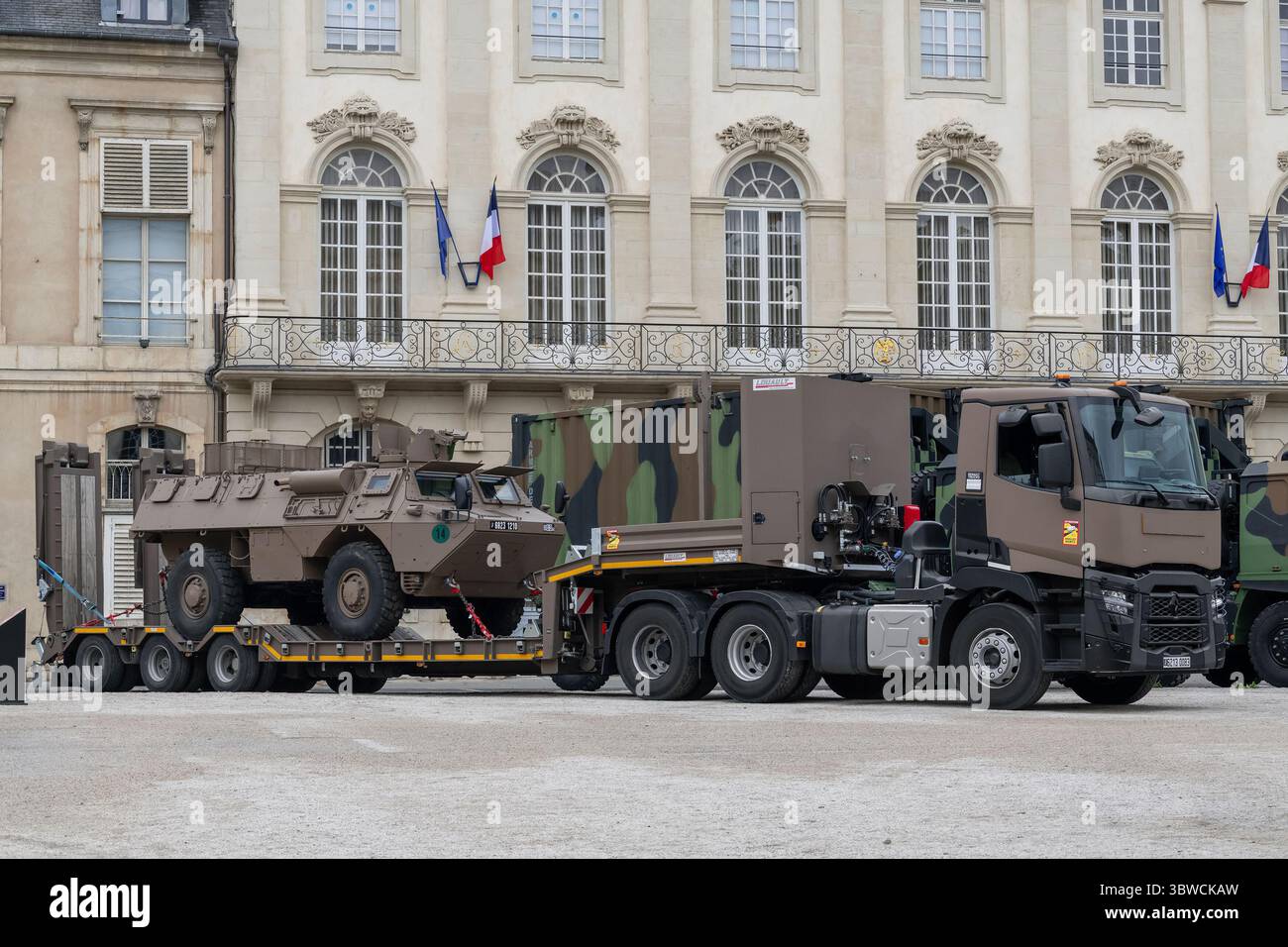 Nancy, Francia - autocarro con caricatore basso dell'esercito francese PEBS, basato su un Renault Trucks C 520 con un veicolo blindato davanti a un rimorchio che guida su una strada. Foto Stock