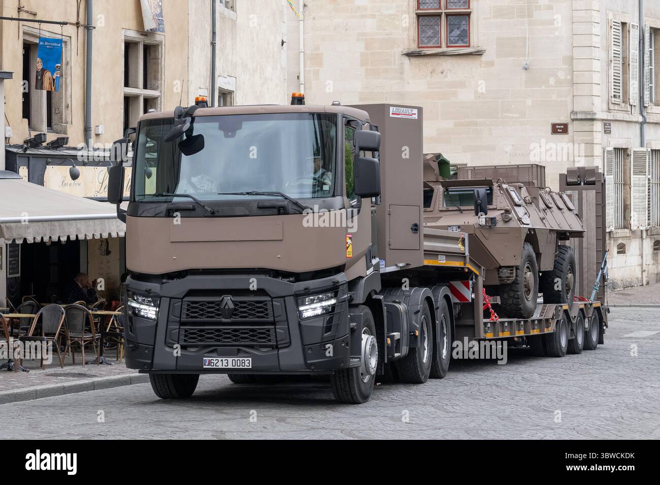 Nancy, Francia - autocarro con caricatore basso dell'esercito francese PEBS, basato su un Renault Trucks C 520 con un veicolo blindato davanti a un rimorchio che guida su una strada. Foto Stock
