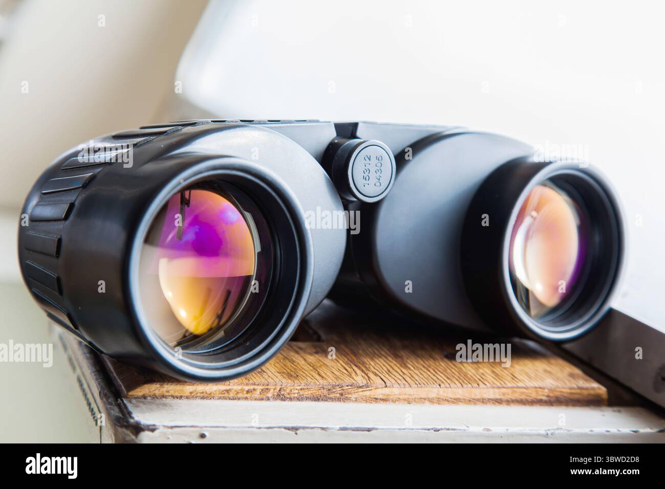 Binocolo su un ponte navale vicino all'oblò. Foto Stock