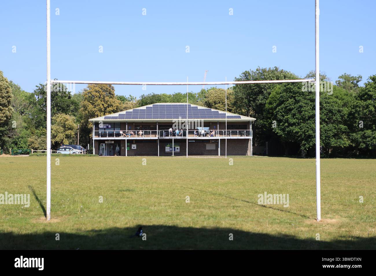 Chichester Rugby club club club club club con pastelli solari sul tetto con pali da rugby in primo piano obiettivo netto zero Oaklands Park Chichester West Sussex Regno Unito Foto Stock