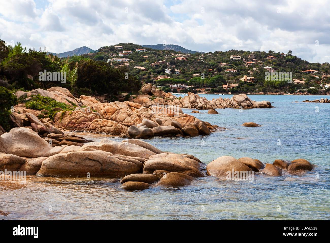 Una vista panoramica della costa rocciosa della Sardegna, in Italia, con acque turchesi cristalline e una lussureggiante vegetazione verde. Il paesaggio nel Mediterraneo. Foto Stock