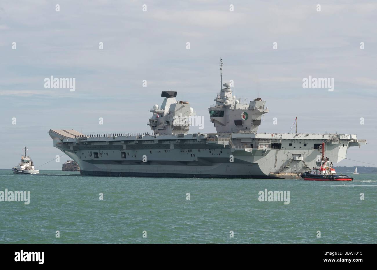 Il Solent Portsmouth Inghilterra Regno Unito. 16.07.2025. HMS Queen Elizabeth con rimorchiatori in navigazione sul Solent in partenza dal porto di Portsmouth. Foto Stock
