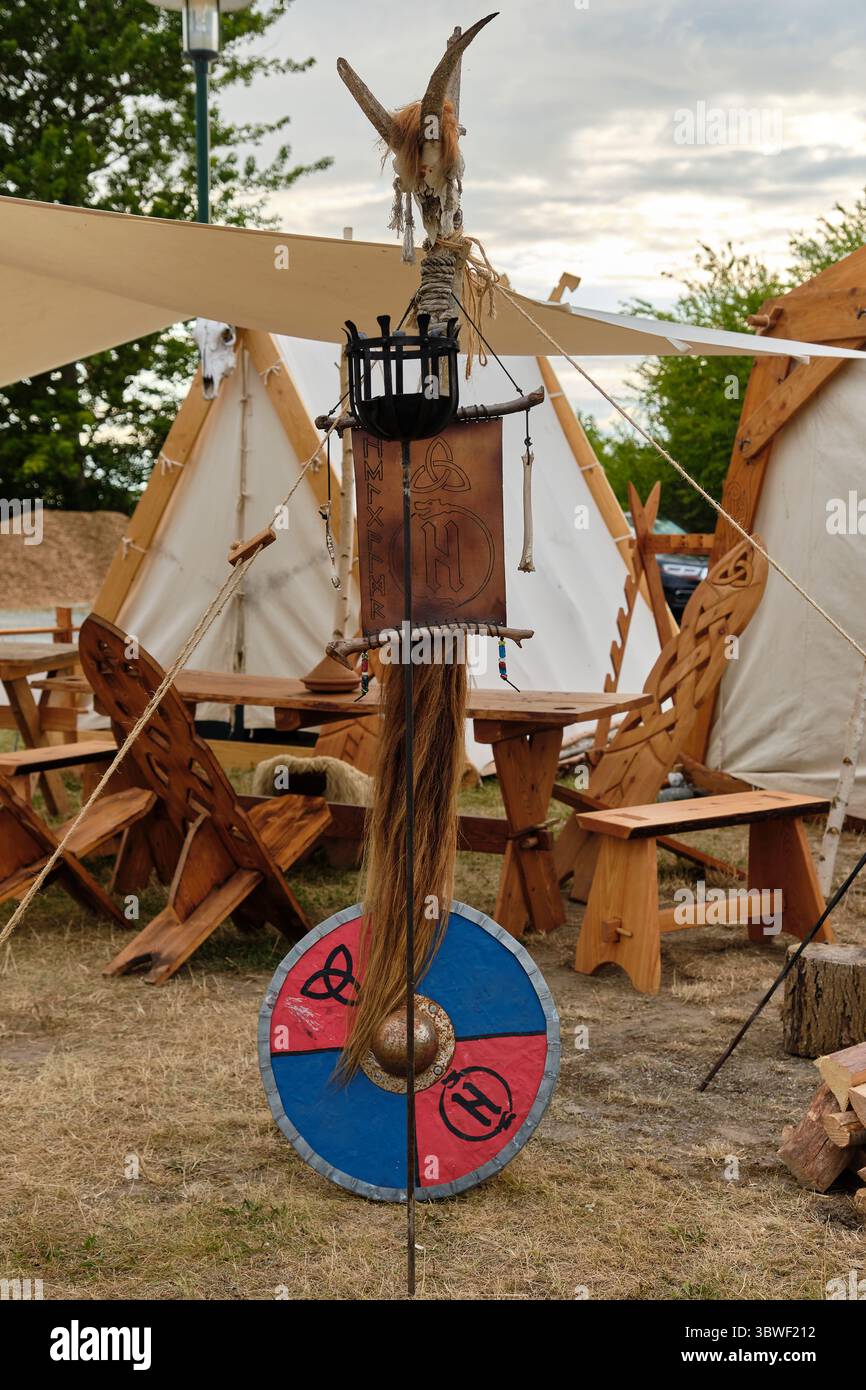 9 luglio 2025 - Putgarten-Germania: Dettaglio di un campo di rievocazione vichinga che mostra una tribuna di metallo con un teschio di animale sulla parte superiore, pelle inscritta con una runa, Foto Stock