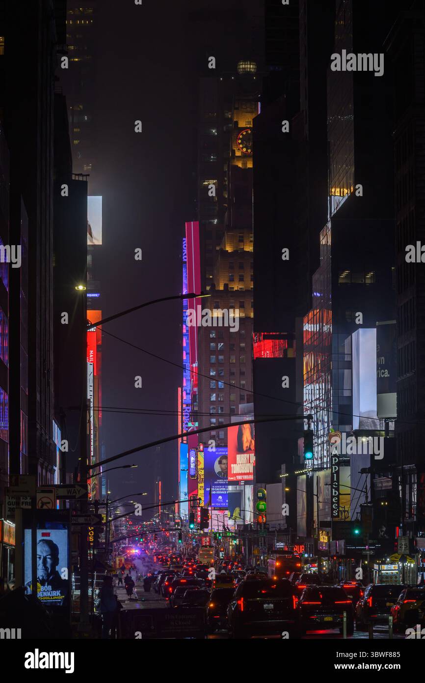 Traffic Queue sulla 7th Avenue, New York, in direzione di Time Square. La scena notturna dominata dal Paramount Building e dalla cartellonistica digitale Bright Lights Foto Stock