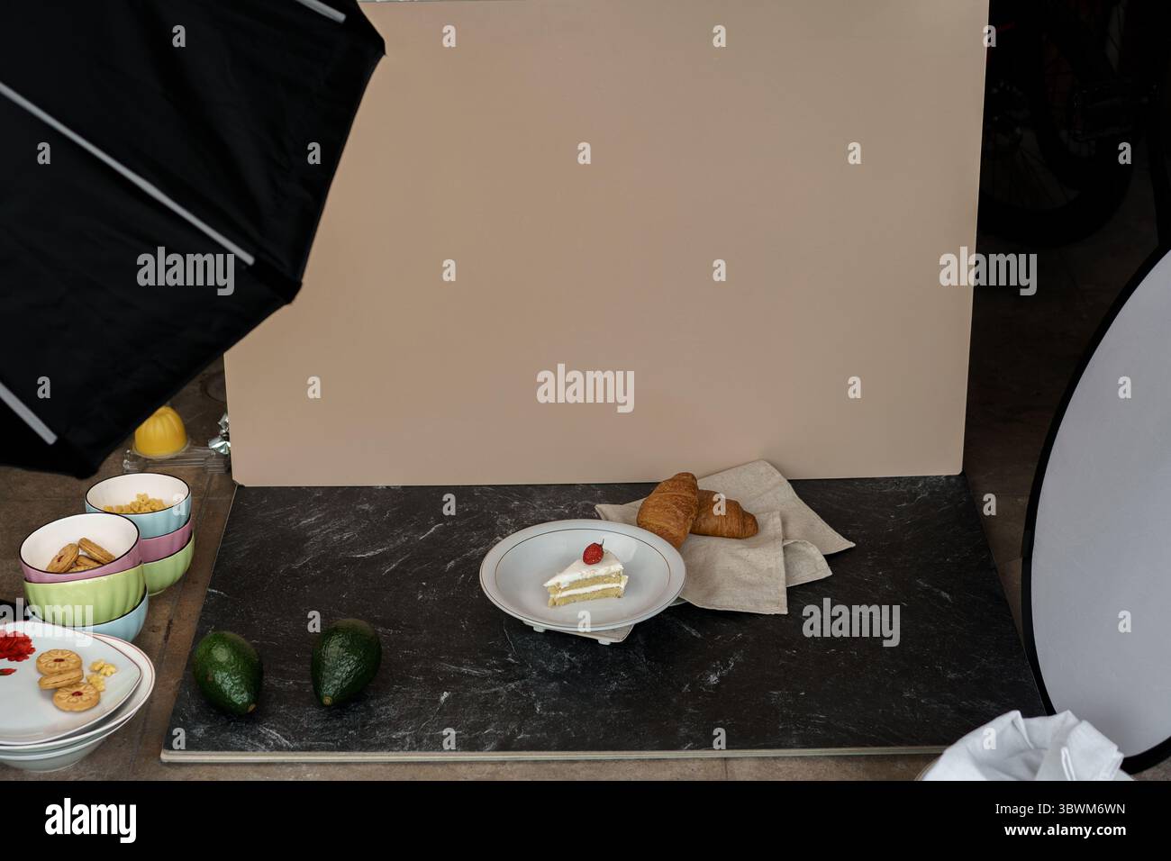 Dietro le quinte della fotografia gastronomica. Torta, croissant e avocado con illuminazione da studio e sfondo per un servizio fotografico commerciale. Foto Stock