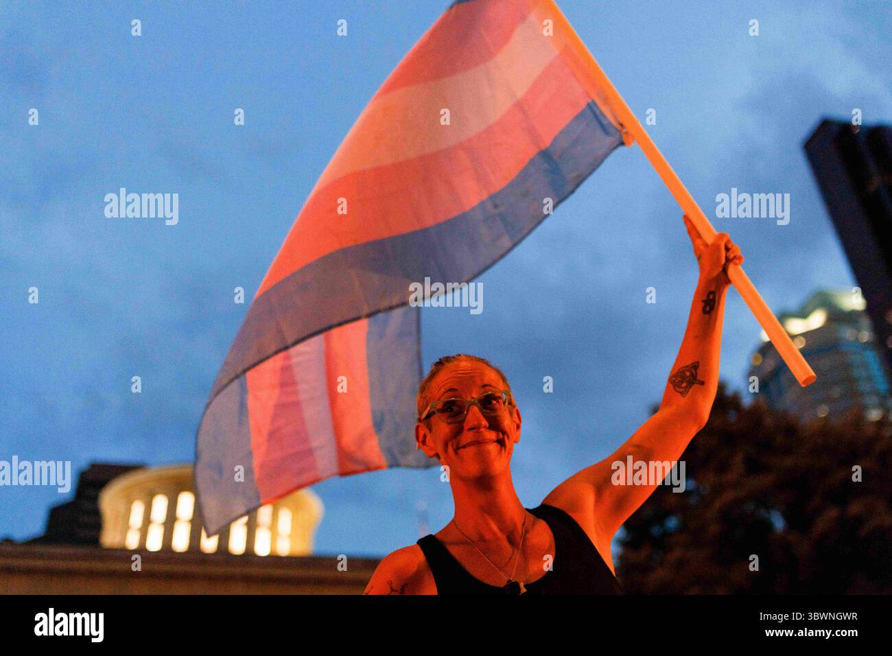 24 giugno 2021, Columbus, Stati Uniti: Cole Ramsey, 39 anni, di South Linden detiene una bandiera di orgoglio transgender di fronte all'Ohio Statehouse per protestare contro l'approvazione di leggi contro le Trans Women che giocano sport nelle scuole superiori e all'università. . – I sostenitori dei diritti transgender si trovavano al di fuori dell’Ohio Statehouse per opporsi e attirare l’attenzione su un emendamento a un disegno di legge che vieterebbe alle donne transgender di partecipare a sport delle scuole superiori e delle università. Il disegno di legge originale secondo cui questo divieto transgender è stato aggiunto per trattare il risarcimento per gli studenti universitari per trarre profitto dal loro nome, immagine e somiglianza Foto Stock