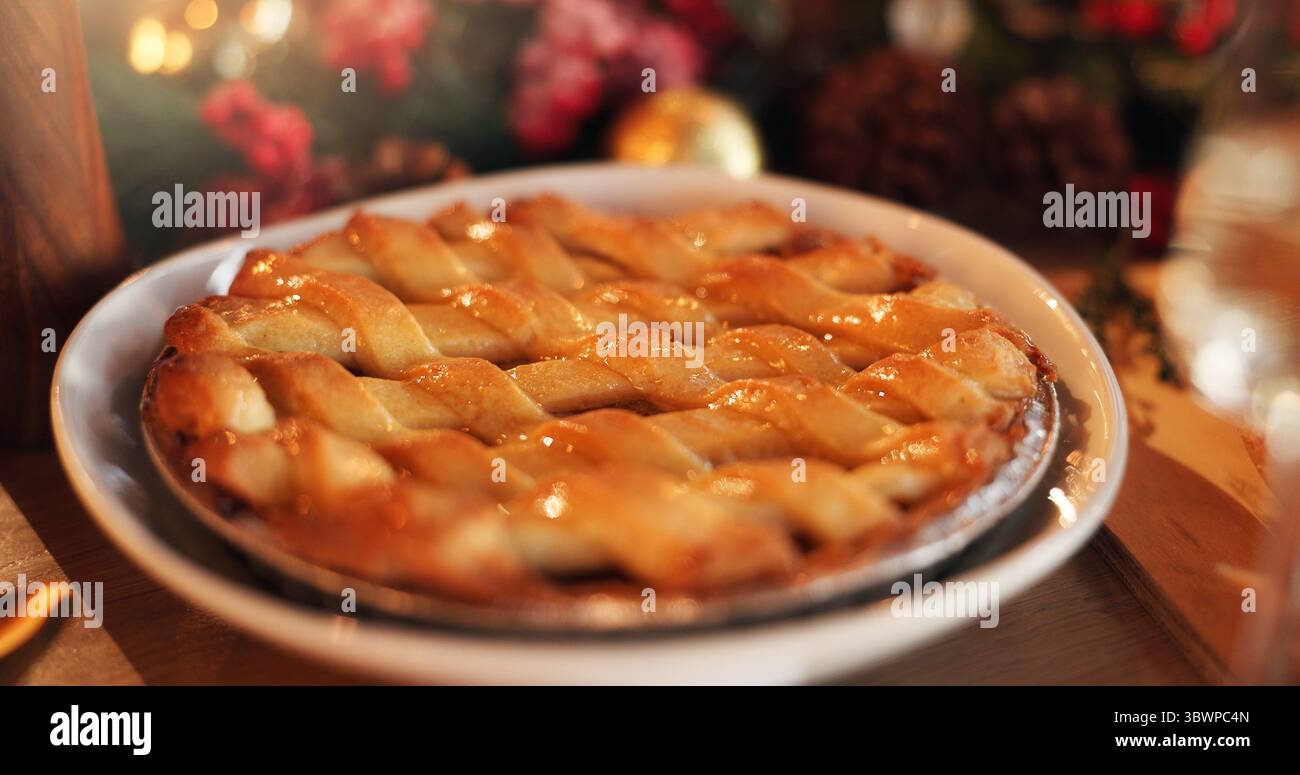Natale, festività e torta di mele in tavola per dessert festivi, tradizione e festeggiamenti. Snack dolce, evento e crostata natalizia in casa per un piatto di pasticceria Foto Stock