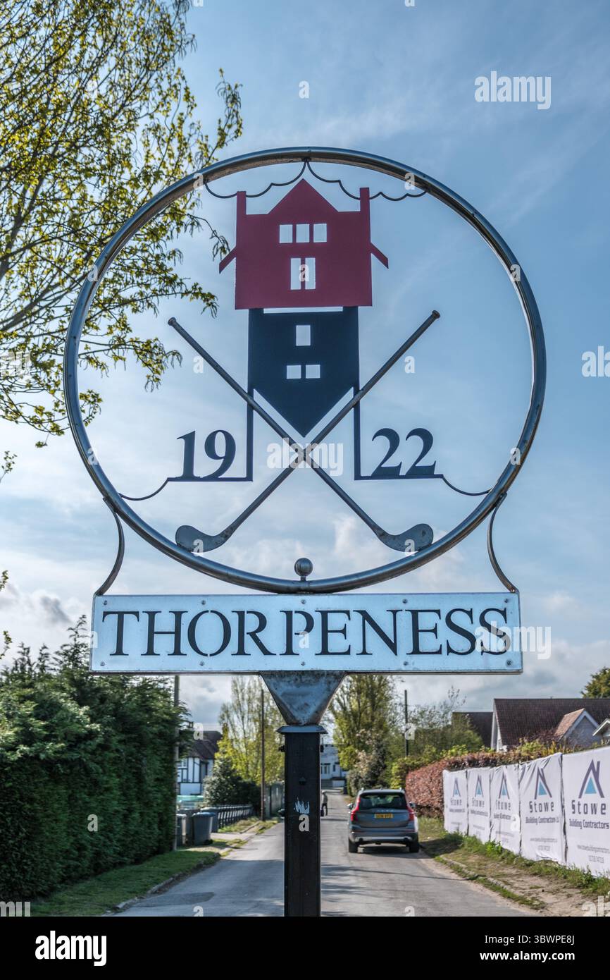 Insegna circolare per Thorpeness, con la House in the Clouds, i club di golf attraversati e l'anno '1922,' adagiato su una strada con un cielo blu Foto Stock
