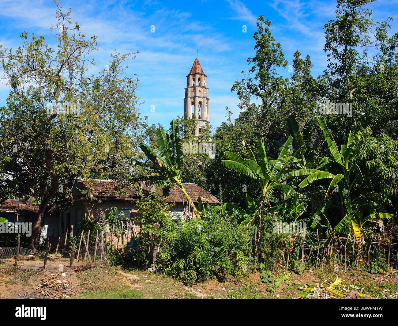 Vista della Torre Manaca Iznaga che sorge sopra la lussureggiante vegetazione tropicale e le case rurali cubane, catturando la storica eredità della piantagione di zucchero vicino a Trinidad, Foto Stock
