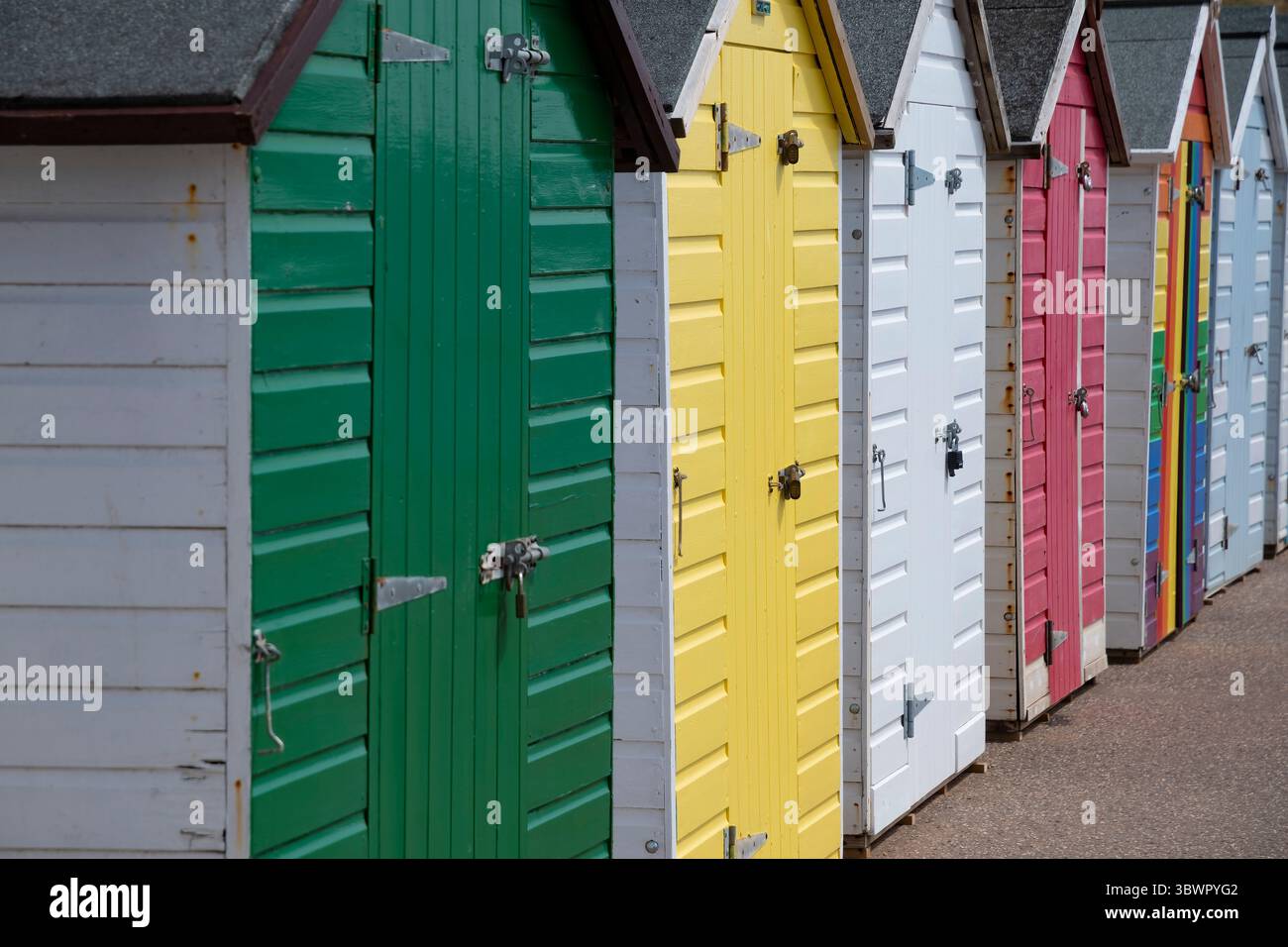 Una fila di colorate capanne sulla spiaggia inglese Foto Stock