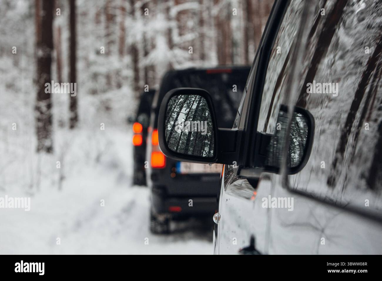 Un gruppo di furgoni va in spedizione nella foresta innevata Foto Stock