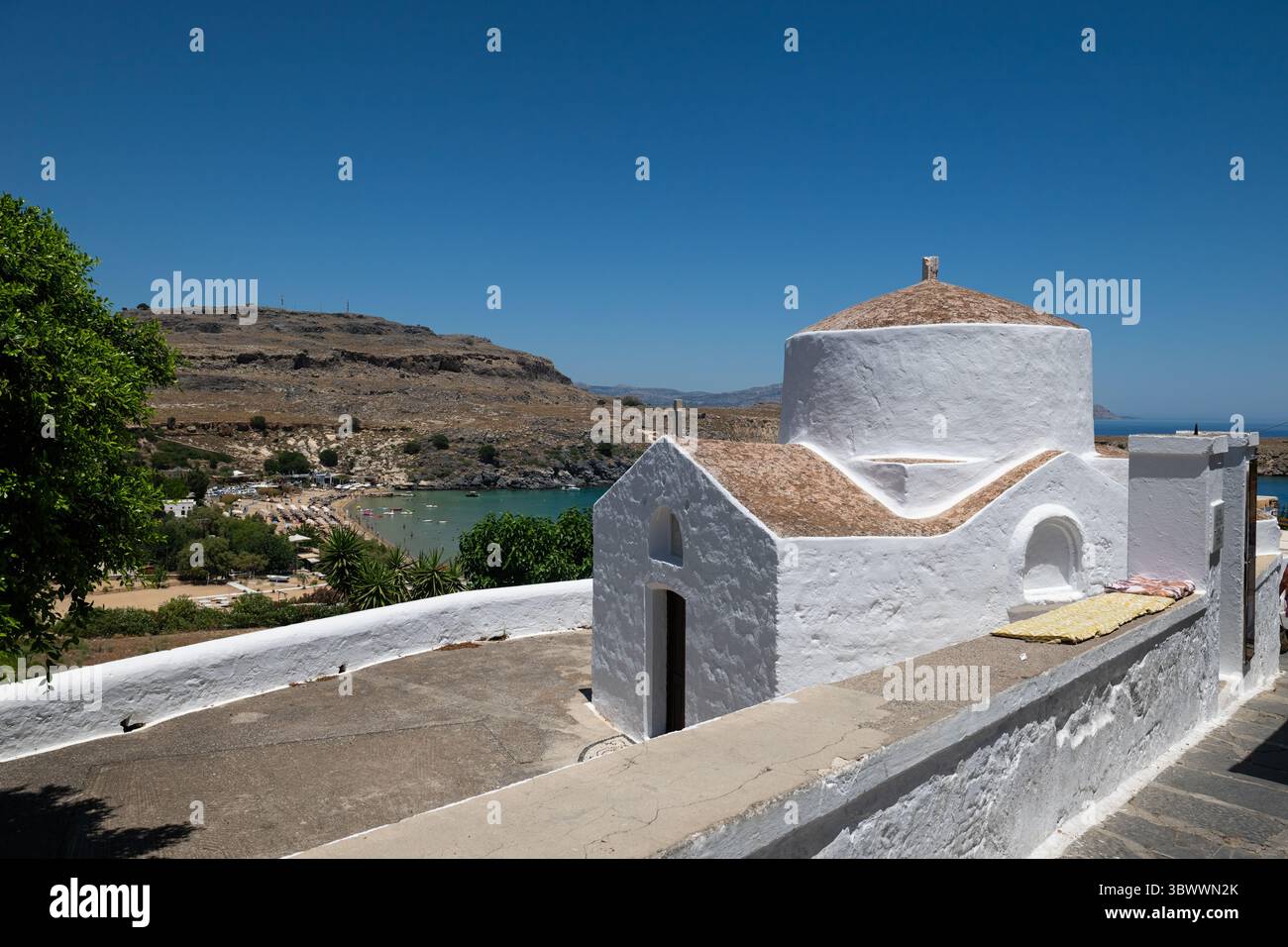 La piccola cappella bianca di San Paolo vicino alla spiaggia di Lindos. Foto Stock