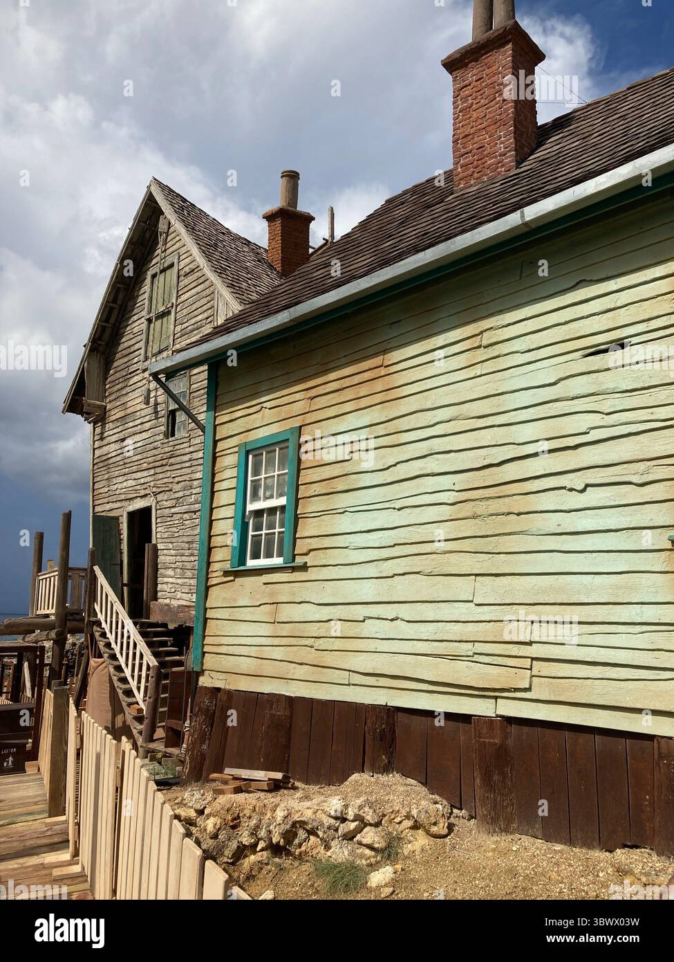 Iconico set cinematografico del villaggio di braccio di ferro e scene di parco divertimenti, con vivaci case in legno, oggetti di scena e la costa di Anchor Bay sotto il giglio del Mediterraneo Foto Stock