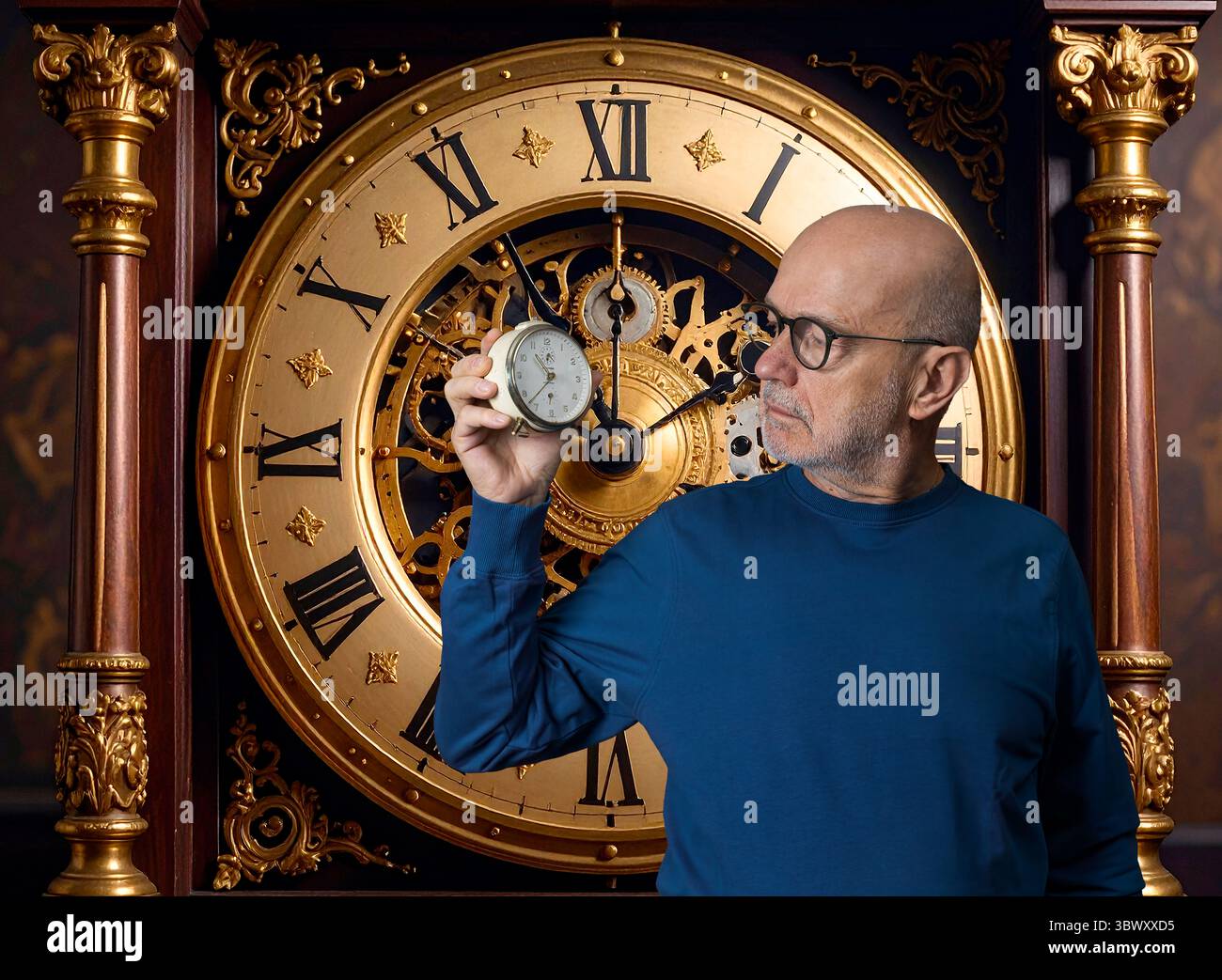un uomo guarda una vecchia sveglia in mano con uno sfondo trasparente Foto Stock