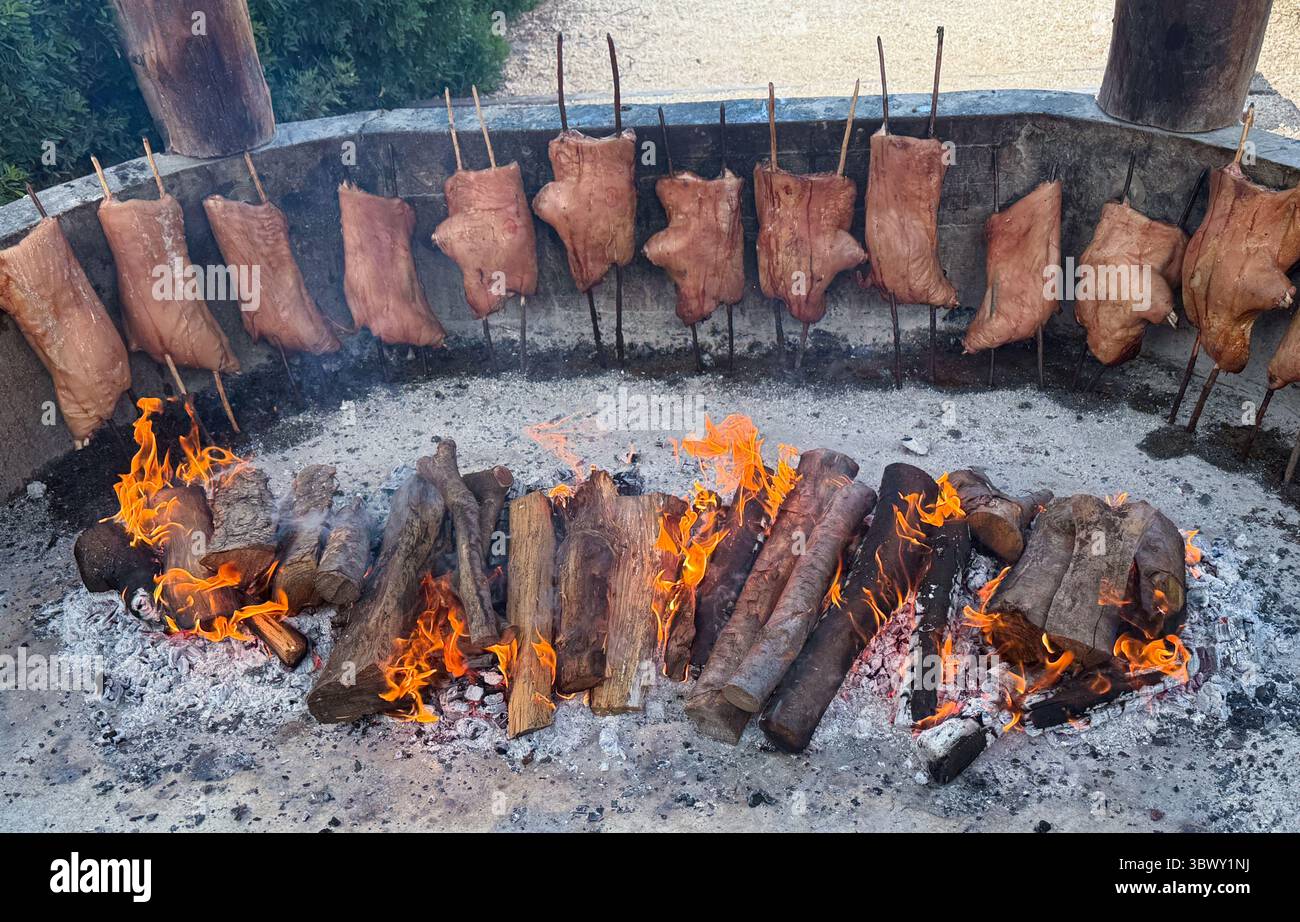 Tagli interi di maiale arrostiti su fuoco aperto in stile tradizionale sardo. Foto Stock