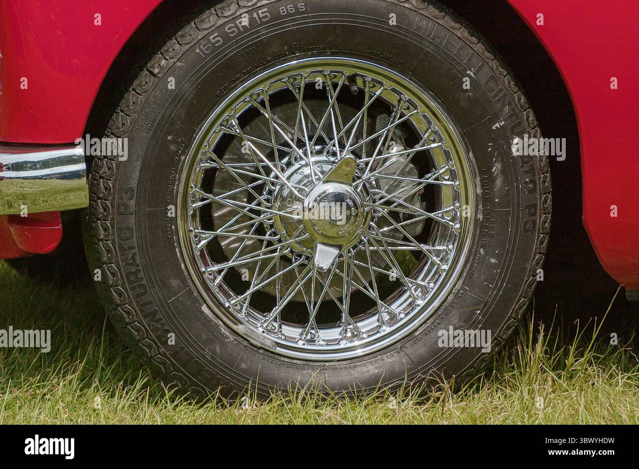 Una ruota metallica cromata montata su un MG rosso in una mostra di veicoli d'epoca nello Yorkshire in Inghilterra Foto Stock