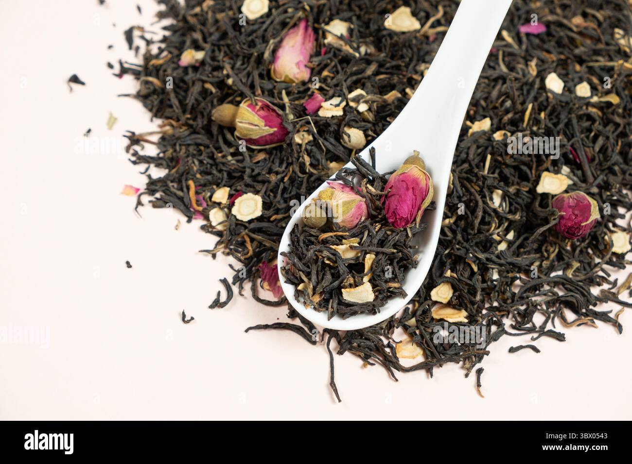Composizione del tè nero con pezzi di ginseng e rose del tè. Foto Stock