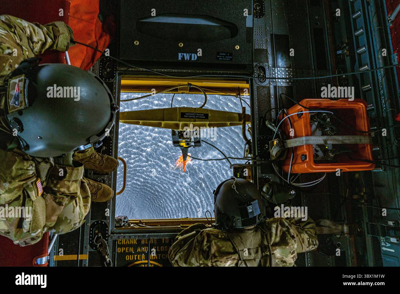 7 agosto 2021 - Grafenwoehr, Bayern, Germania - U.S. Army staff Sgt. Tyler Vermillion, ingegnere di volo e capo equipaggio, Right, e staff Sgt. Patrick Smith, istruttore di standardizzazione e capo equipaggio, entrambi assegnati alla Bravo Company, 1st Battalion, 214th Aviation Regiment, parte della 12th Combat Aviation Brigade, guarda fuori dalla botola inferiore di un elicottero Chinook 47 al secchio d'acqua sospeso durante l'addestramento aereo antincendio, Germania, 7 agosto 2021. Vermillion usa un telecomando per controllare e catturare l'acqua. (Foto di staff Sgt. Christopher Stewart) Foto Stock
