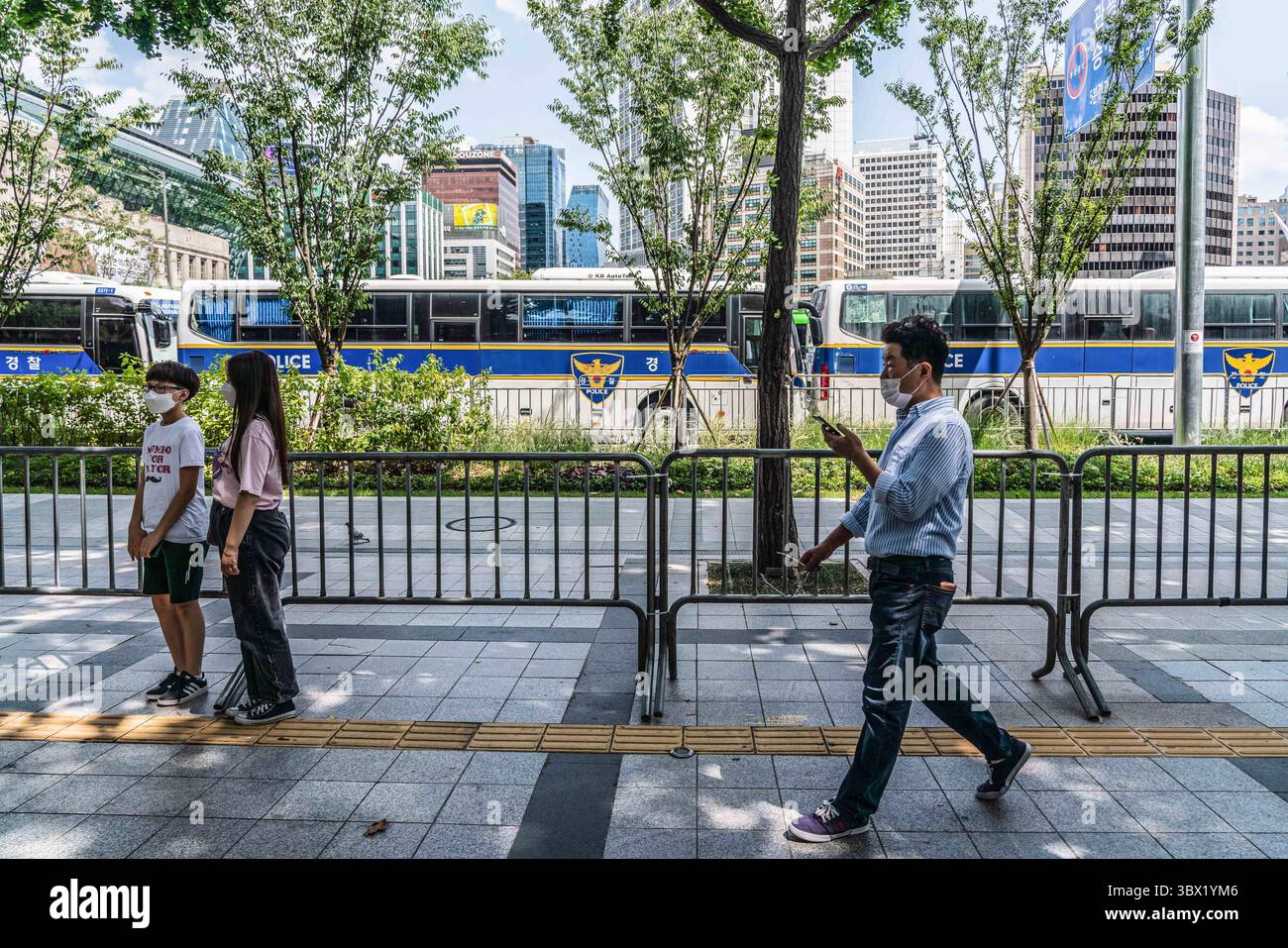 15 agosto 2021, Seoul, Corea del Sud: Le persone che indossano maschere facciali camminano lungo recinzioni e muri degli autobus a Seoul. La polizia sudcoreana crea muri e posti di blocco per bloccare i manifestanti a Seoul. La Corea del Sud ha bandito le proteste in vista della giornata nazionale della liberazione, protestando contro la ripresa dell'epidemia di coronavirus causata da una manifestazione anti-governativa dello scorso agosto. (Immagine di credito: © Simon Shin/SOPA Images via ZUMA Press Wire) Foto Stock