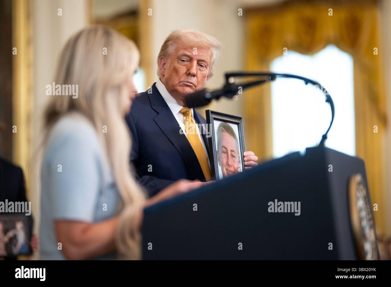 Il presidente Donald Trump tiene una foto di una vittima di overdose di fentanyl durante un incontro con le famiglie Angel durante una cerimonia della Casa Bianca in coincidenza con la firma della legge HALT Fentanyl. 16 luglio 2025. Washington, DC, immagine gentilmente concessa dalla Casa Bianca. Foto Stock