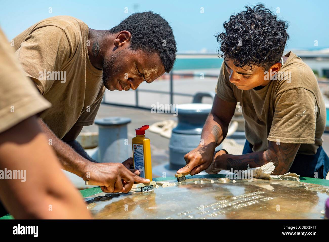 9 agosto 2021 - Bahrain - Boatswain's Mate 3rd Class Treshuan Gray, Left, e Boatswain's Mate Seaman Christopher Andino, entrambi assegnati alla nave da sbarco classe Harpers Ferry USS Carter Hall (LSD 50), polacco un capstan sul foc'S'le della nave, 9 agosto 2021. Carter Hall è schierato nell'area di operazioni della 5th Fleet degli Stati Uniti a sostegno delle operazioni navali per garantire la stabilità e la sicurezza marittima nella regione centrale, collegando il Mediterraneo e il Pacifico attraverso l'Oceano Indiano occidentale e tre punti strategici di strozzatura. (Foto di Mass Communication Specialist 3rd Class Sawyer Connally) ( Foto Stock