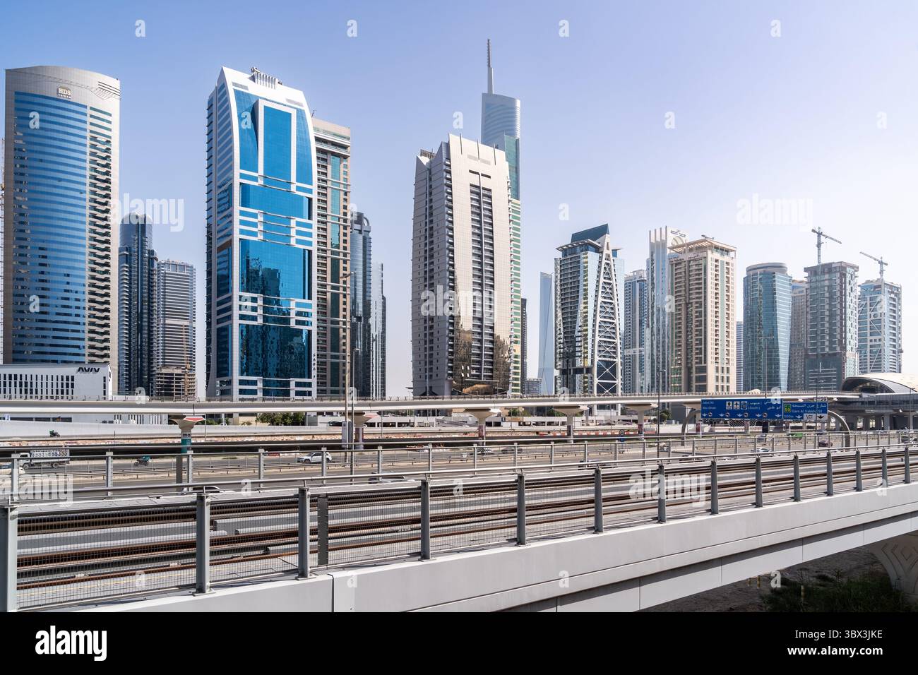 Dubai, Emirati Arabi Uniti - 17 marzo 2023: Serie di moderni grattacieli che seguono una delle strade di Dubai in una giornata di sole Foto Stock
