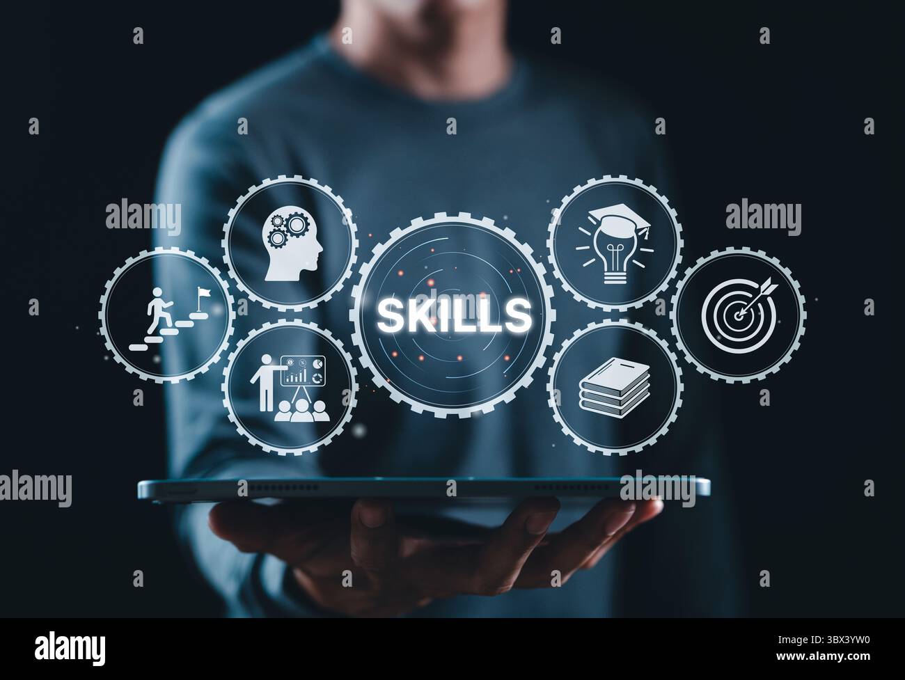 Sviluppo delle competenze e formazione professionale. L'uomo d'affari possiede un tablet che mostra icone di attrezzi con la parola "ABILITÀ", che rappresenta la conoscenza, Foto Stock