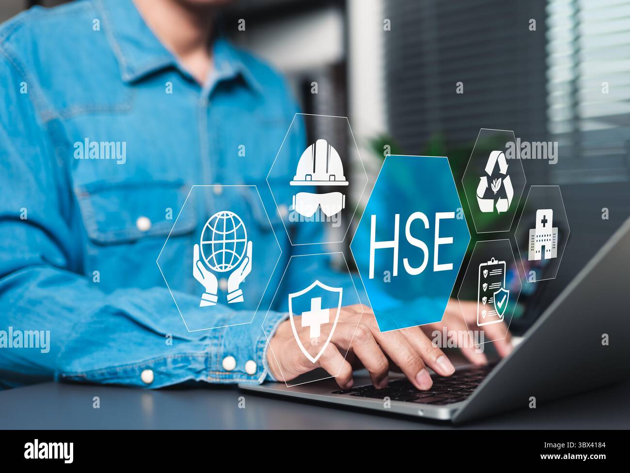 Concetto HSE per la salute e la sicurezza sul luogo di lavoro. Uomo d'affari che utilizza un computer portatile con icone che rappresentano salute, sicurezza e protezione ambientale, Foto Stock
