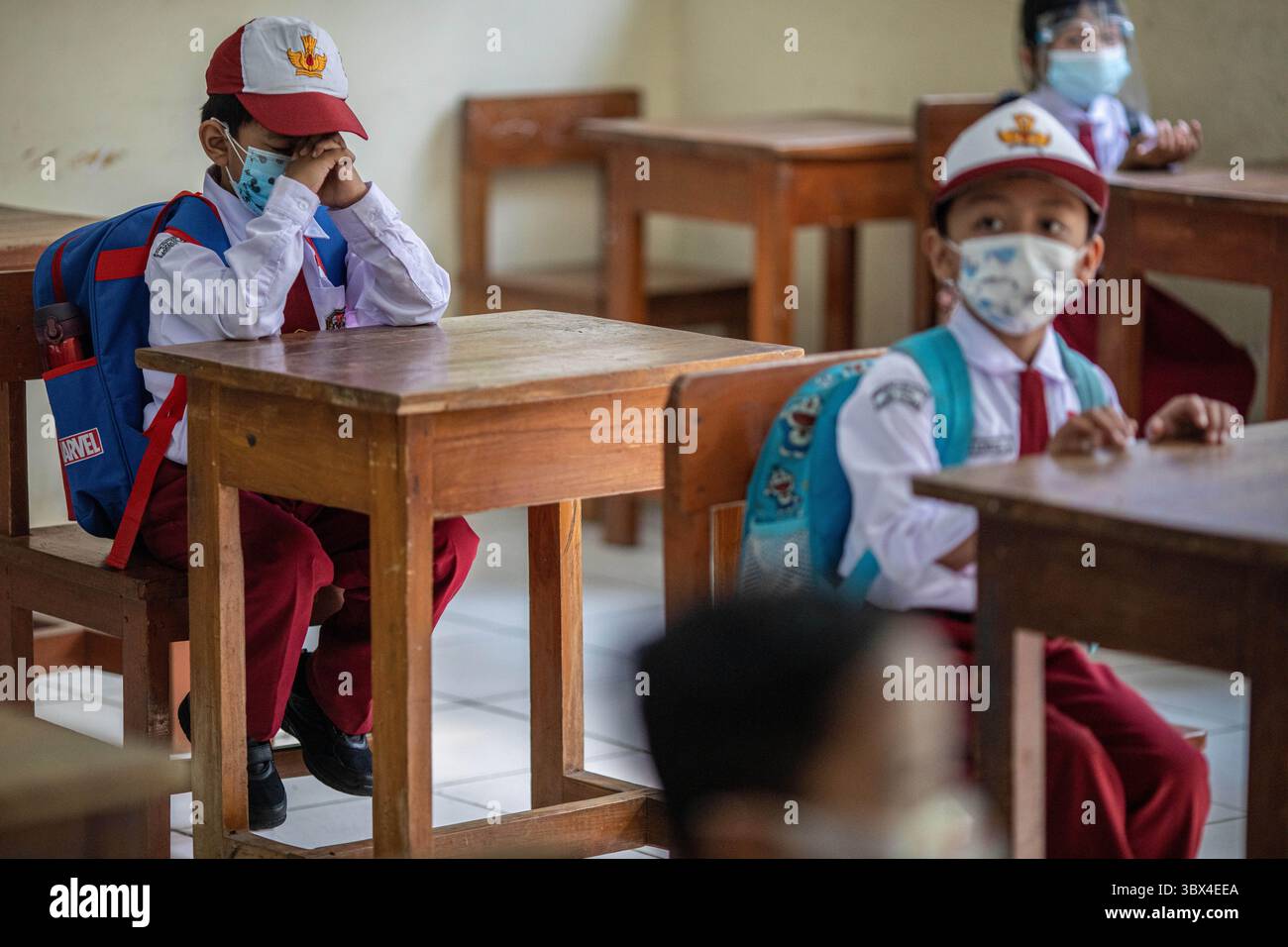 30 agosto 2021, Giacarta Selatan, Giacarta, Indonesia: Un bambino prega prima di lasciare la classe durante le attività scolastiche presso la scuola elementare 14, Giacarta sud. Dopo molto tempo, le scuole faccia a faccia sono state chiuse in Indonesia a causa della pandemia di COVID-19, a partire dal 30 agosto 2021, le scuole inizieranno ad aprirsi con protocolli sanitari rigorosi e limitando il numero di studenti che arrivano solo al 50%. (Immagine di credito: © Donal Husni/ZUMA Press Wire) Foto Stock