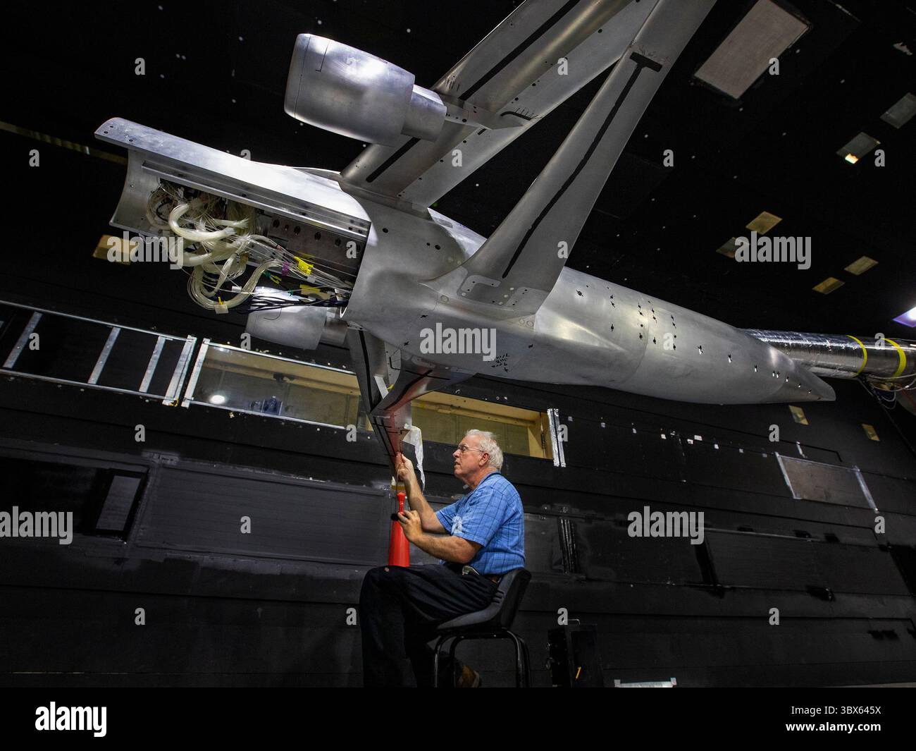 7 settembre 2021 - Langley, Virginia, Stati Uniti - il tecnico di strumentazione Michael Hodgins esegue le misure di installazione sul modello ad ala con rinforzo a trave (TTBW) trans-sonico presso il tunnel del vento subsonico 14x22 del Langley Research Center. Il design esclusivo delle ali dell'aereo riduce la resistenza durante il volo, riducendo il consumo di carburante fino al 10%. Questo concetto fa parte di un'iniziativa in corso da parte della NASA, dei partner industriali e del mondo accademico per rendere il futuro dell'aviazione più rispettoso dell'ambiente attraverso la Sustainable Flight National Partnership (SFNP). La SFNP amplierà la ricerca per su Foto Stock