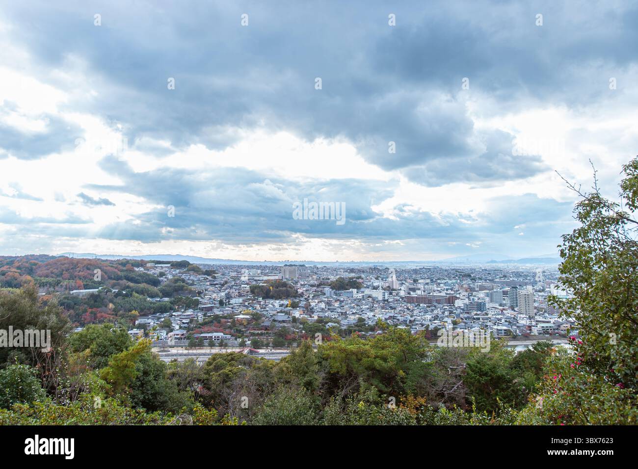 Vista panoramica da Daikichiyama a Uji, in Giappone, che mostra la città sotto le nuvole spettacolari e circondata da colline color autunno. Foto Stock