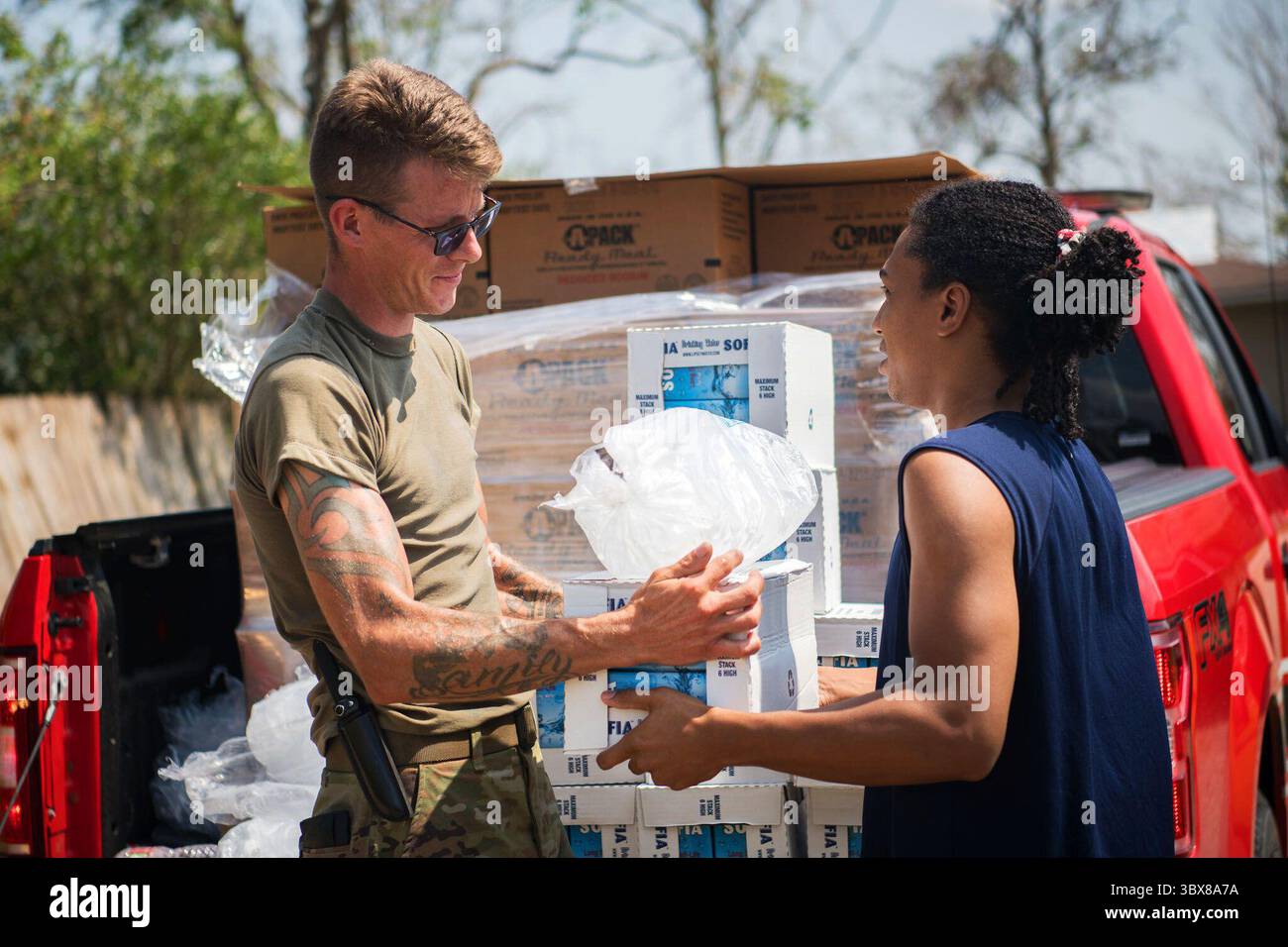7 settembre 2021 - Louisiana, USA - Oklahoma National Guardsman SPC. Bryan Stanley, sergente di rifornimento della 1245th Transportation Company, 345th Combat Sustainment Support Battalion, 90th Troop Command, mani ghiaccio e acqua ad un residente di un quartiere a Laplace, Louisiana, 7 settembre 2021. Le guardie nazionali dell'Oklahoma hanno guidato attraverso i quartieri per distribuire rifornimenti direttamente ai residenti della Louisiana, consentendo aiuti essenziali per raggiungere rapidamente la popolazione locale. (Foto di Senior Airman Alex Kaelke) (immagine di credito: © U.S. National Guard/ZUMA Press Wire Service/ZUMAPRESS.com) Foto Stock