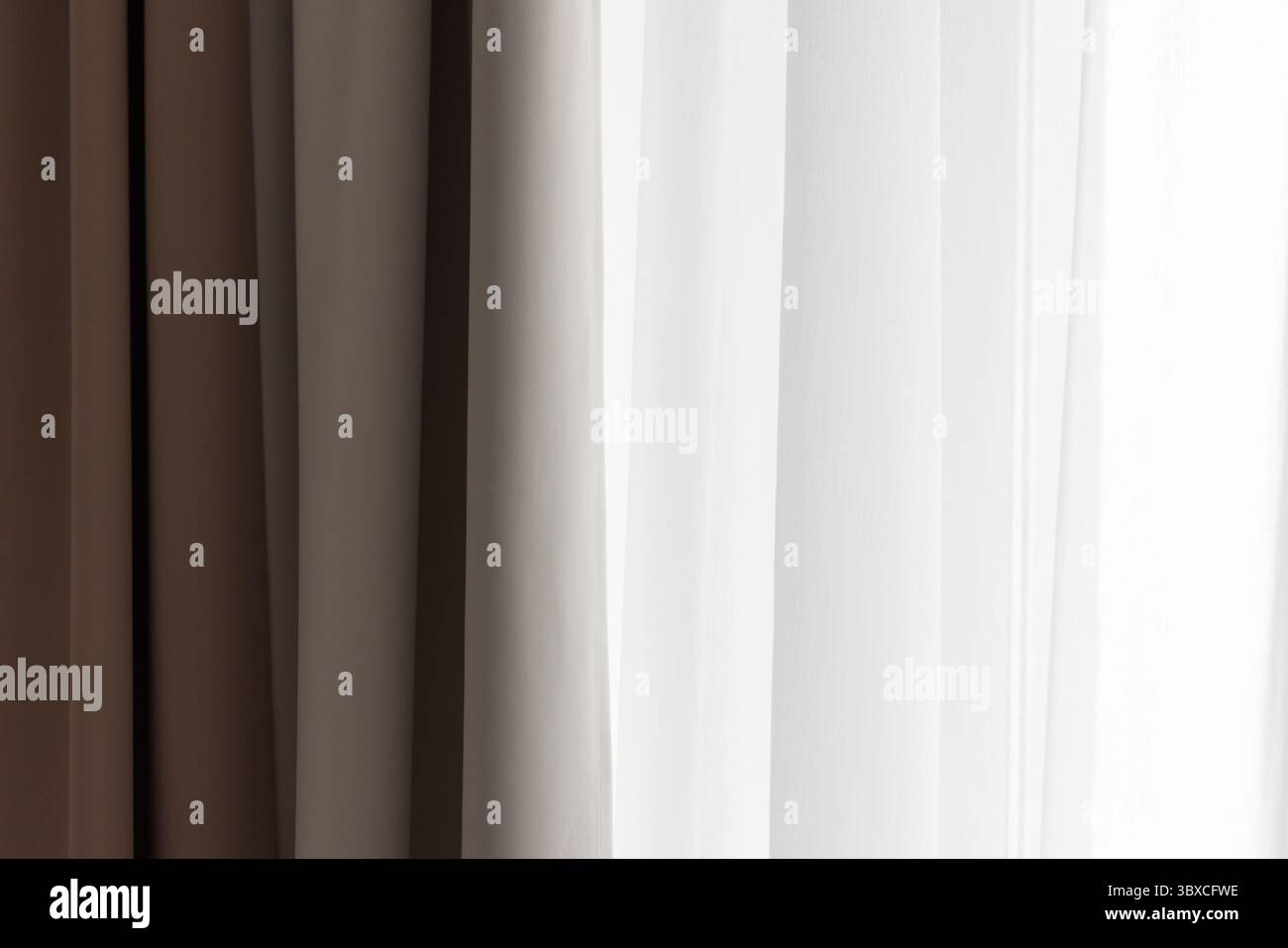 Tende dai toni neutri splendidamente disposte in tonalità morbide, che consentono di illuminare delicatamente la luce naturale da uno sfondo luminoso, creando un'atmosfera unica Foto Stock