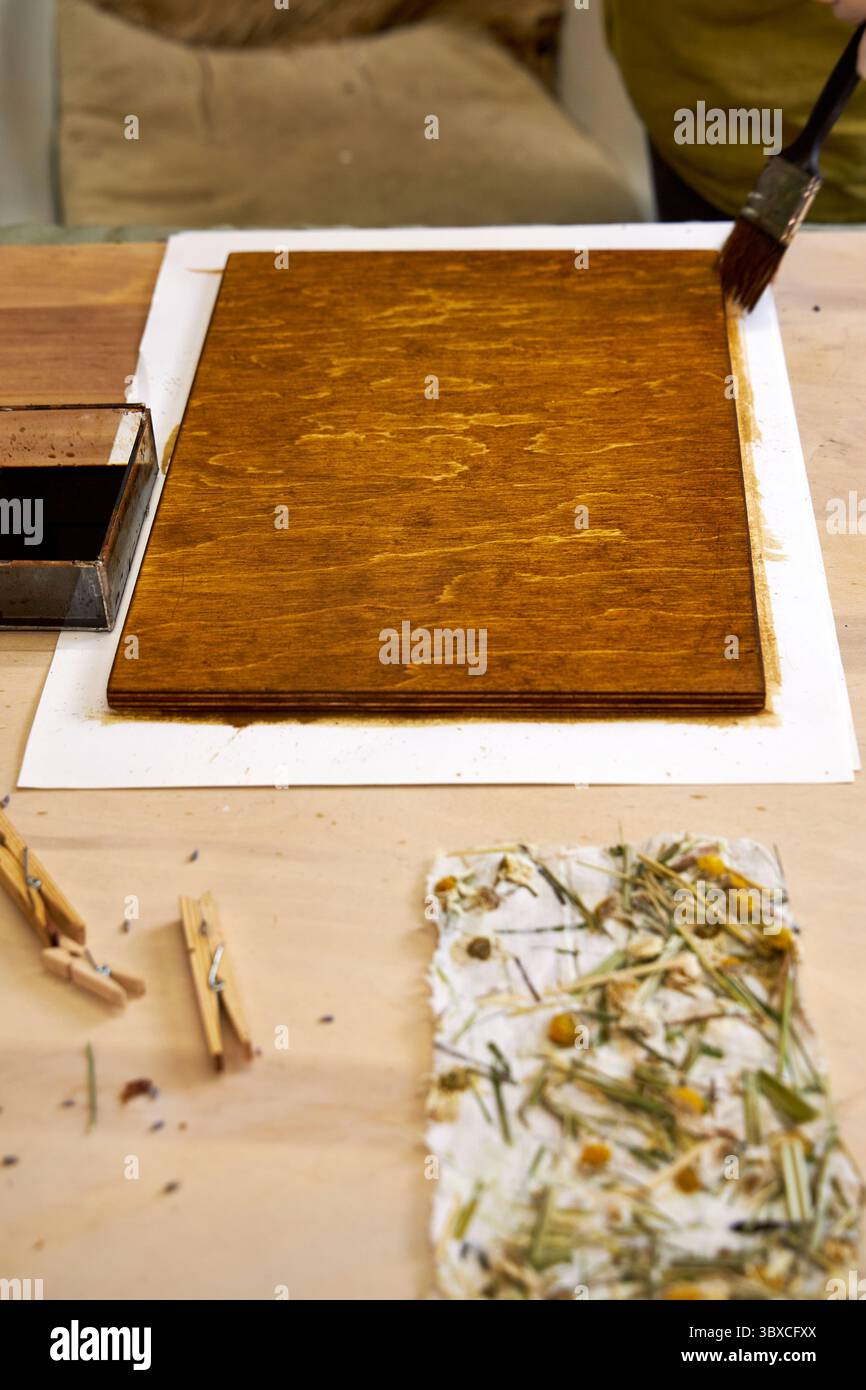Pannello in legno spazzolato per artigianato decorativo con carta floreale fatta a mano. Progetto artistico ecologico con materiali naturali e carta botanica. DI creativo Foto Stock