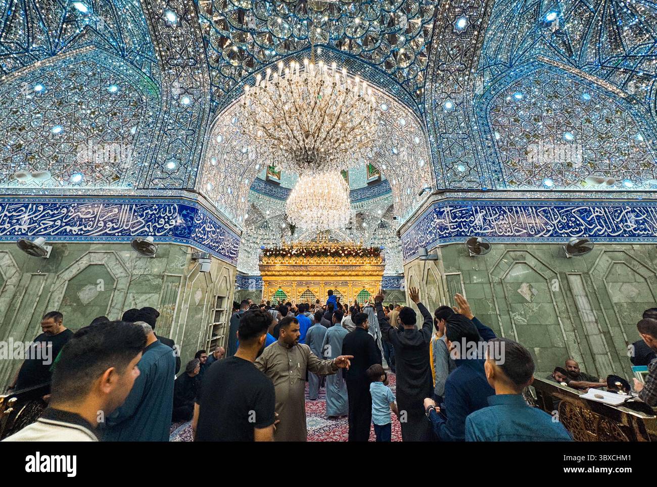 La gente si riunisce al santuario dell'Imam Hussain a Karbala, Iraq, apprezzando le intricate decorazioni durante un evento religioso significativo. Foto Stock