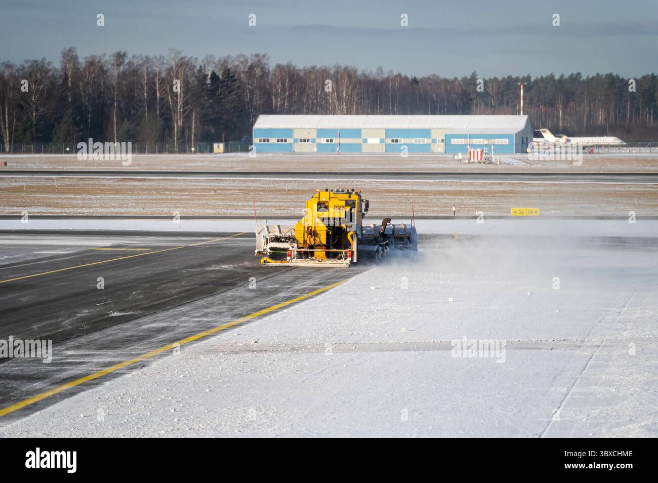 Riga, Lettonia - 15 febbraio 2025: Operazioni di rimozione della neve presso l'aeroporto internazionale di riga utilizzando attrezzature specializzate Foto Stock