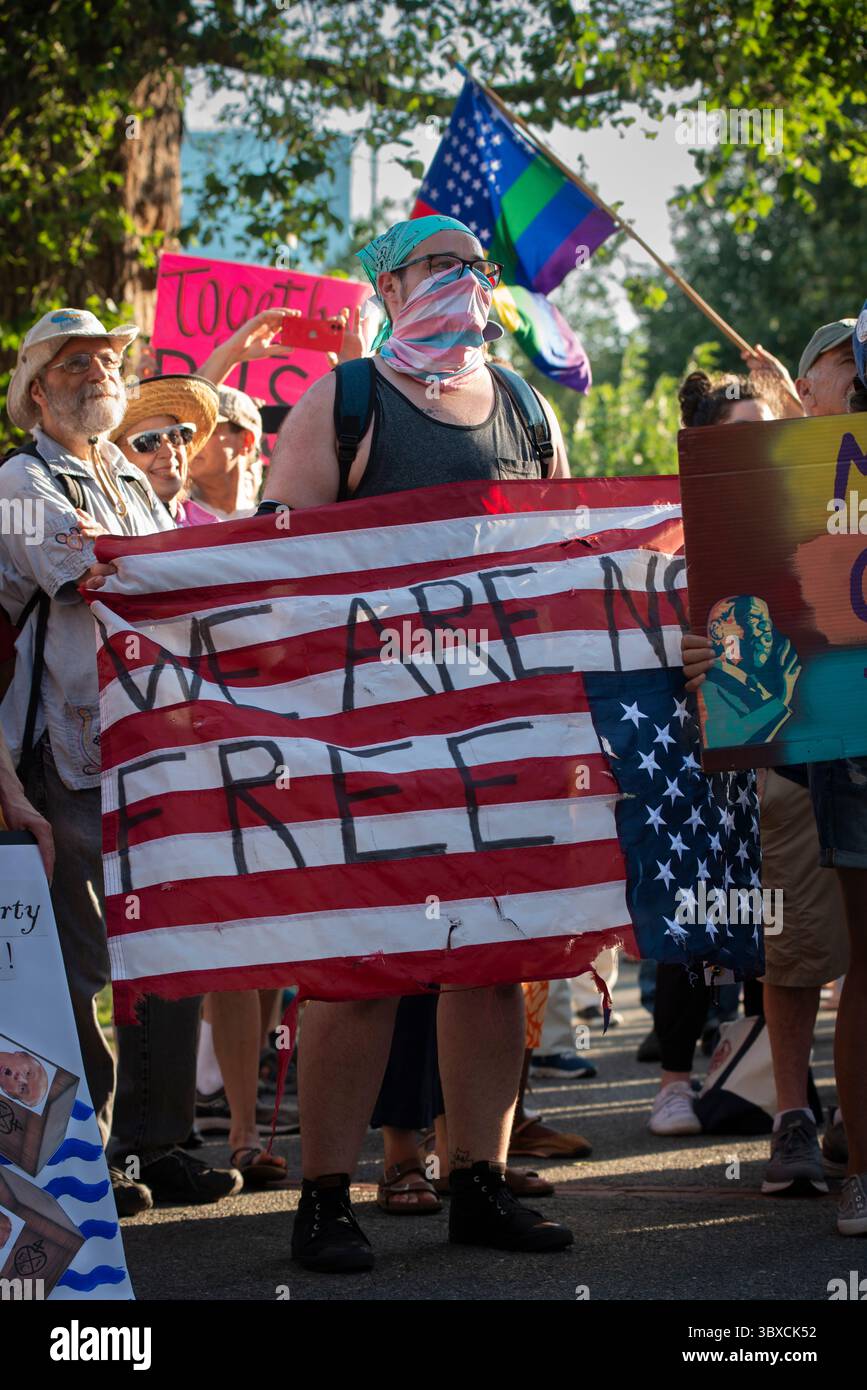 Boston, Massachusetts, Stati Uniti. 17 luglio 2025. Centinaia hanno partecipato a "Good Trouble Lives On" al Liberty Mall sul Boston Common nel quinquennale della morte di John Lewis, leader dei diritti civili e membro del Congresso degli Stati Uniti d'America, John Lewis (1940-2020), oltre 1.000 gruppi hanno preso parte alle manifestazioni in tutto il paese. La foto mostra RJ, 32 di Boston, che tiene una bandiera americana rovesciata con scritto "WE ARE NOT FREE". Crediti: Chuck Nacke / Alamy Live News Foto Stock