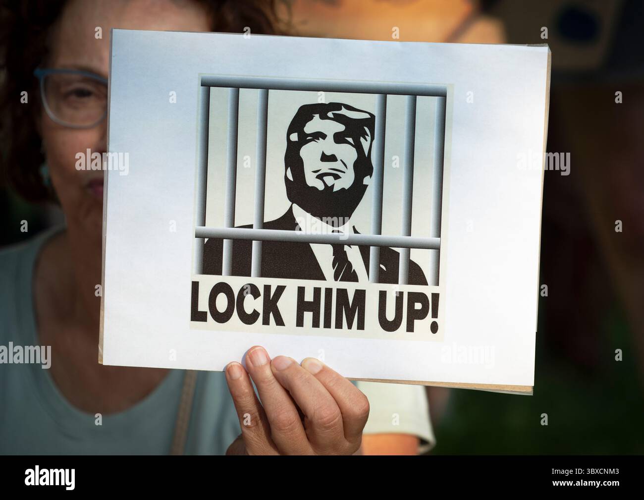 Boston, Massachusetts, Stati Uniti. 17 luglio 2025. Centinaia hanno partecipato a "Good Trouble Lives On" al Liberty Mall sul Boston Common nel quinquennale della morte di John Lewis, leader dei diritti civili e membro del Congresso degli Stati Uniti d'America, John Lewis (1940-2020), oltre 1.000 gruppi hanno preso parte alle manifestazioni in tutto il paese. Foto: Donna che tiene in mano un piccolo poster che mostra Donald Trump dietro le sbarre con "CHIUDILO!" stampato sotto di lui. Crediti: Chuck Nacke / Alamy Live News Foto Stock