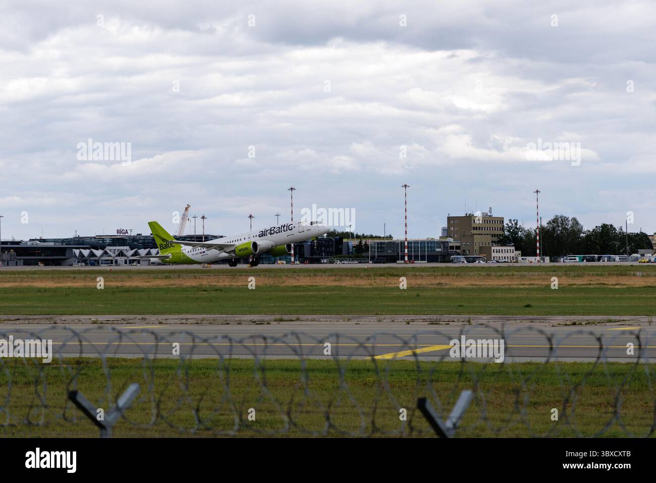 RIGA/LETTONIA – 07.06.2025: Un aereo AirBaltic decolla dall'aeroporto internazionale di riga, mostrando i moderni viaggi aerei e una compagnia aerea chiave del Baltico. Foto Stock