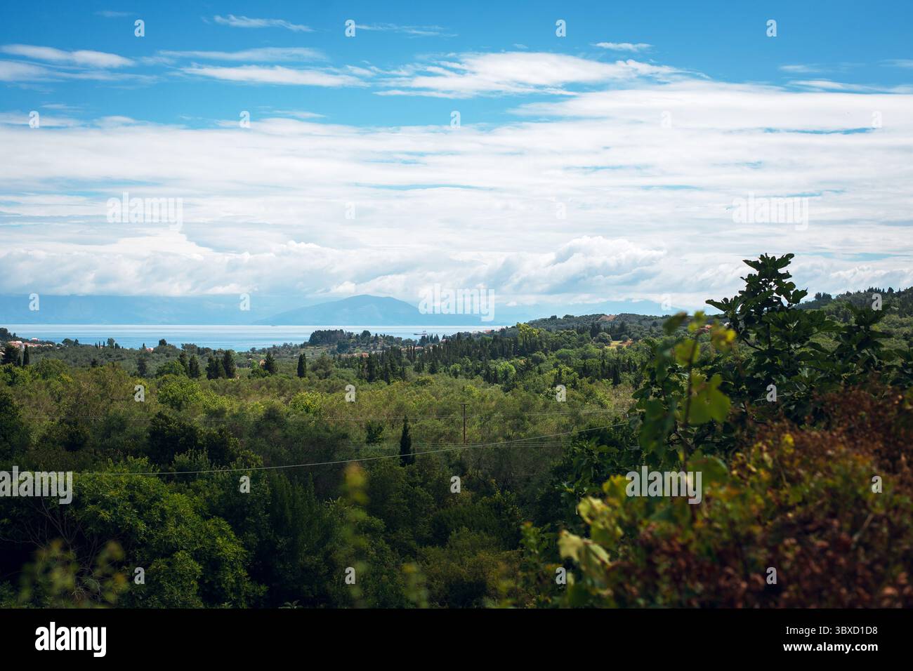 Colline panoramiche e Mare sotto il cielo nuvoloso Foto Stock