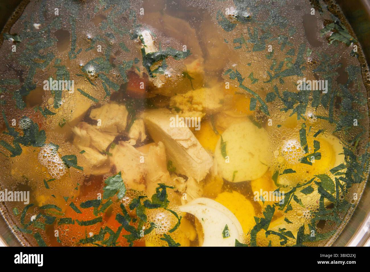Zuppa di pollo trasparente con filetti di pollo, patate, carote e cipolle. Foto Stock