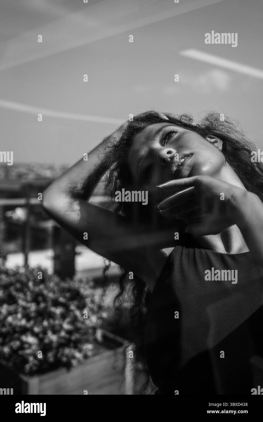 La donna posa in un moody ritratto riflesso sul tetto in bianco e nero Foto Stock