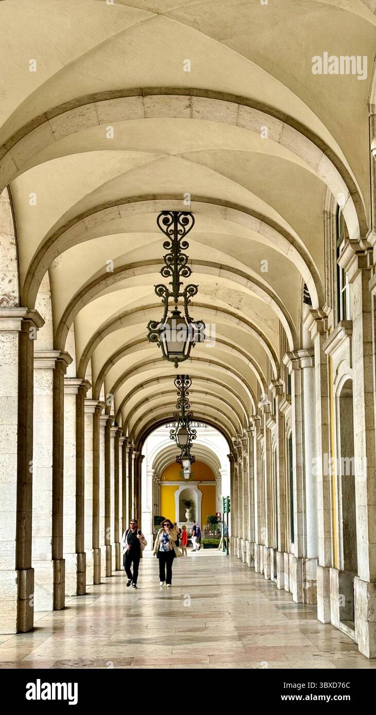 Pedoni che camminano sotto il portico dell'edificio del Ministero della giustizia che fiancheggia Prac do Comércio Lisbona Portogallo - Immagine stock catturata con smartphone