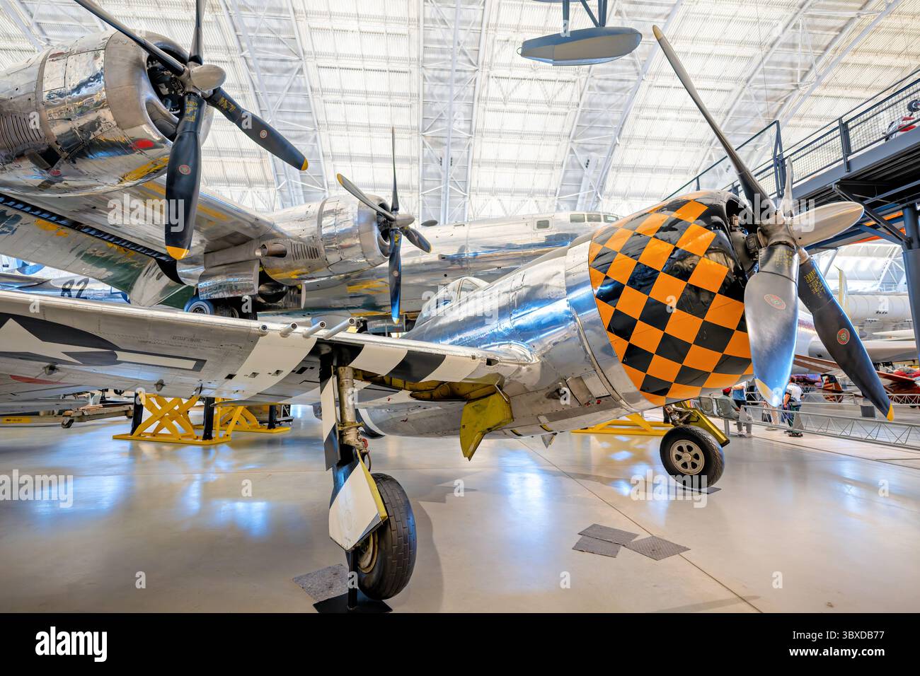 CHANTILLY, Virginia - l'aereo da caccia Republic P-47D Thunderbolt è esposto allo Smithsonian's National Air and Space Museum Udvar-Hazy Center, con l'Enola Gay visibile sullo sfondo. Questo P-47D-30-RA fu consegnato a Godman Field, Kentucky, nel 1944 e servì come addestratore di armi aeree prima di essere trasferito allo U.S. Air Force Museum e poi allo Smithsonian. Il P-47 Thunderbolt, equipaggiato con un motore radiale Pratt & Whitney R-2800-59 Double Wasp da 2.000 cavalli e armato con otto mitragliatrici calibro .50, era considerato uno dei tre migliori caccia americani di Wor Foto Stock