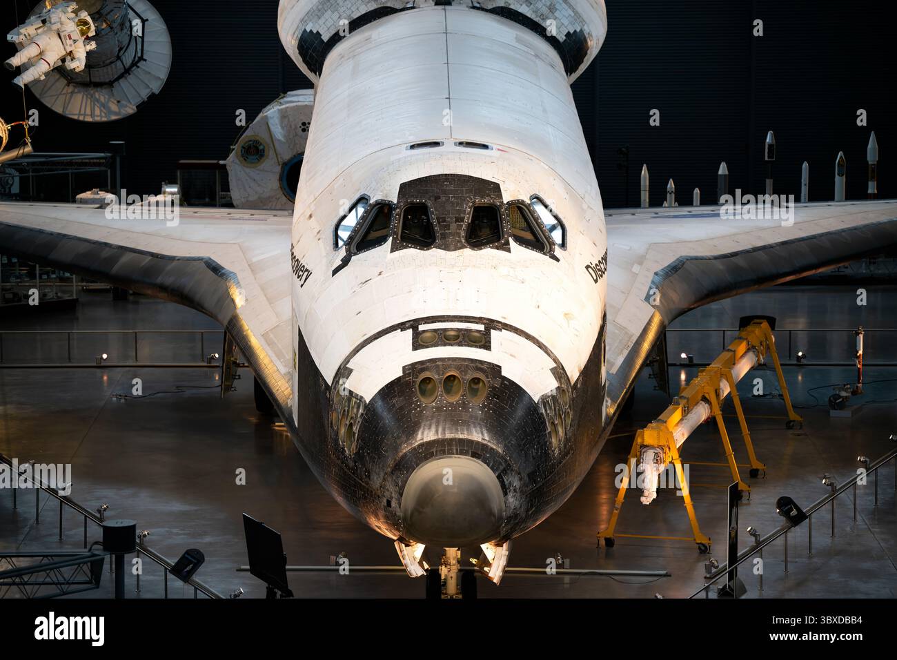 Space Shuttle Discovery display presso lo Steven F Udvar-Hazy Center a Chantilly Virginia | CHANTILLY, Virginia - la cabina di pilotaggio e il cono del naso dello Space Shuttle Discovery dominano questa cornice presso lo Steven F. Udvar-Hazy Center, con un manichino astronauta e l'hardware della stazione sospesi nelle vicinanze. Discovery è l'orbiter più volato nella storia della NASA, completando 39 missioni, e rimane il "veicolo di registrazione" designato dall'agenzia, conservato con le sue piastrelle indossate in volo intatte. Foto Stock