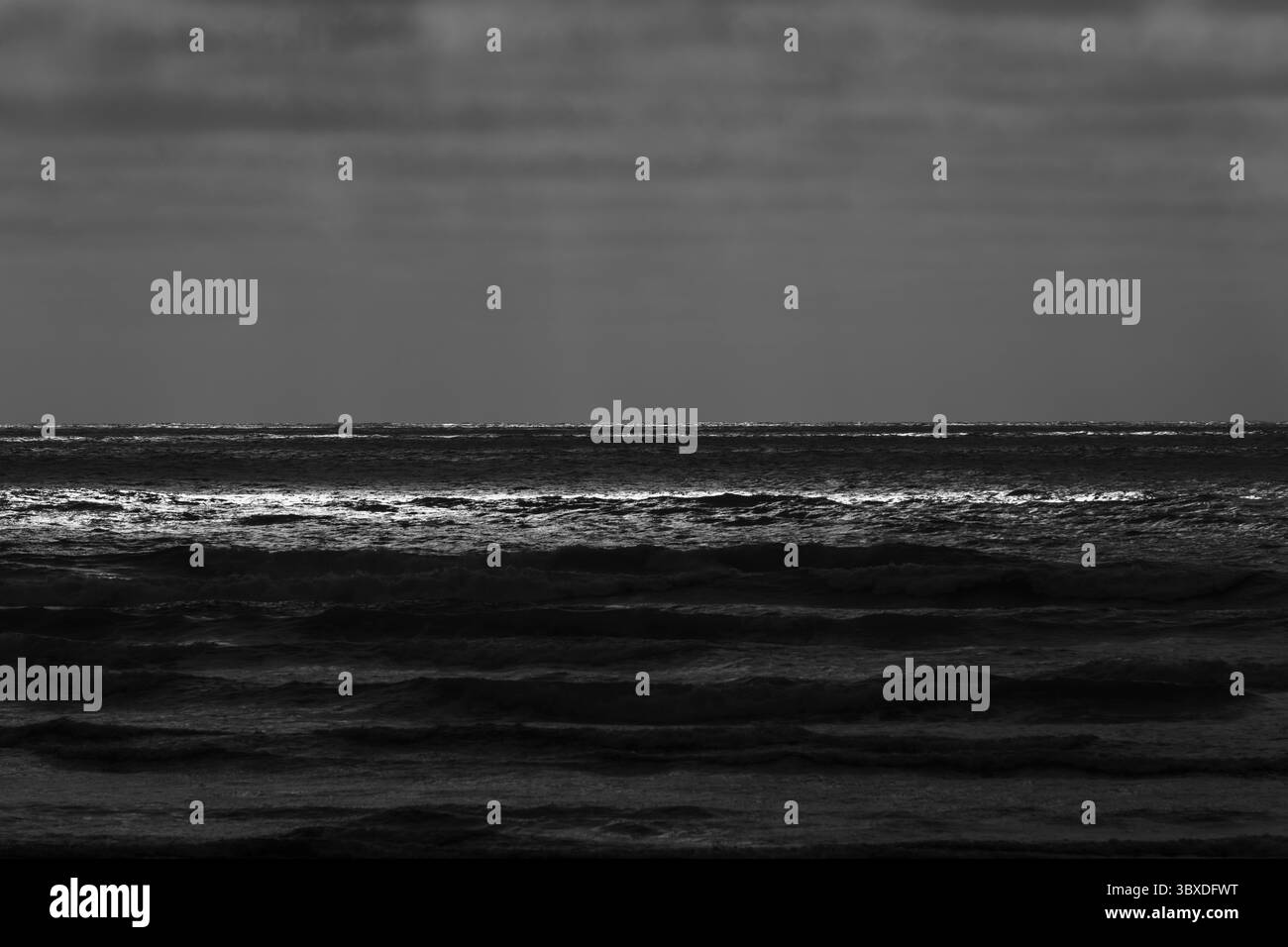 Onde infranti e cielo coperto al crepuscolo Foto Stock